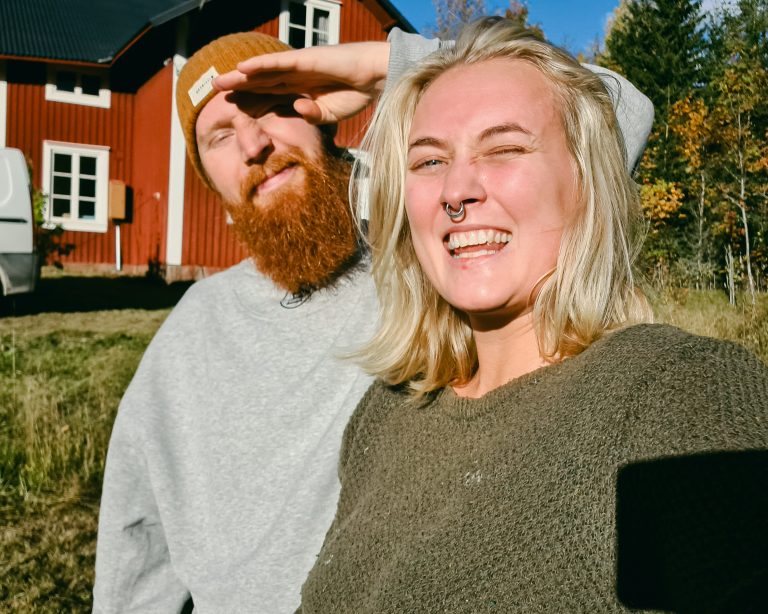 A man and a woman taking a selfie in the warm rays from the spring sun in Sweden