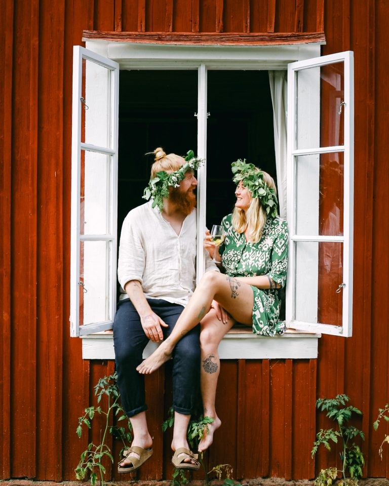 Volunteer hosts in Sweden taking a happy midsummer photo in a window