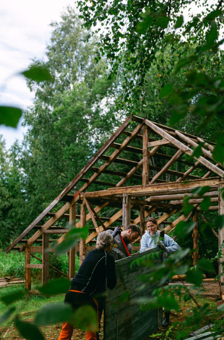 Volunteers working with building a tiny house in the Swedish woods