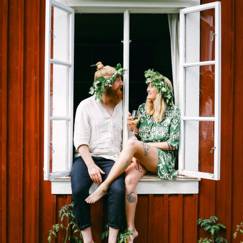 Volunteer hosts in Sweden taking a happy midsummer photo in a window