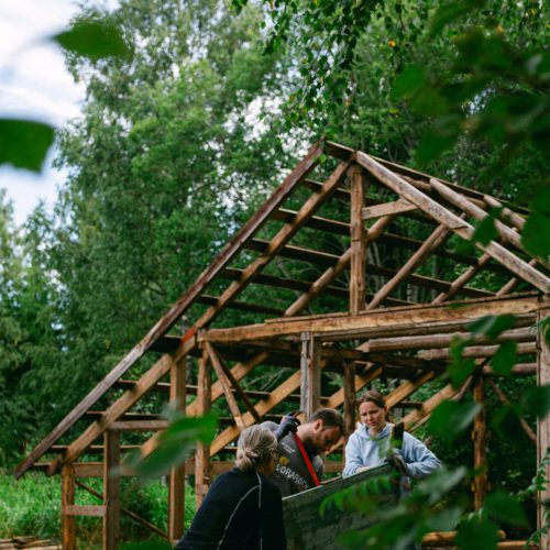 Volunteers working with building a tiny house in the Swedish woods